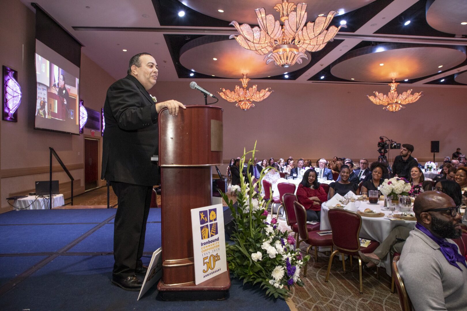 A man giving a speech at a banquet.