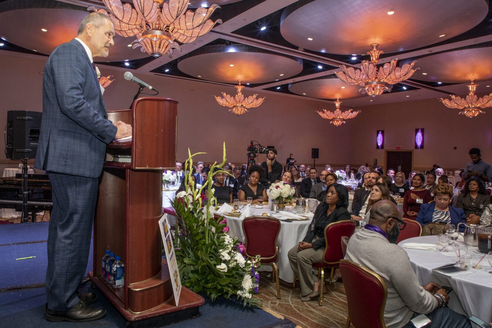 A man giving a speech at a banquet.