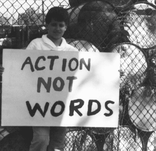 A Boy Holding an Action Not Words Banner