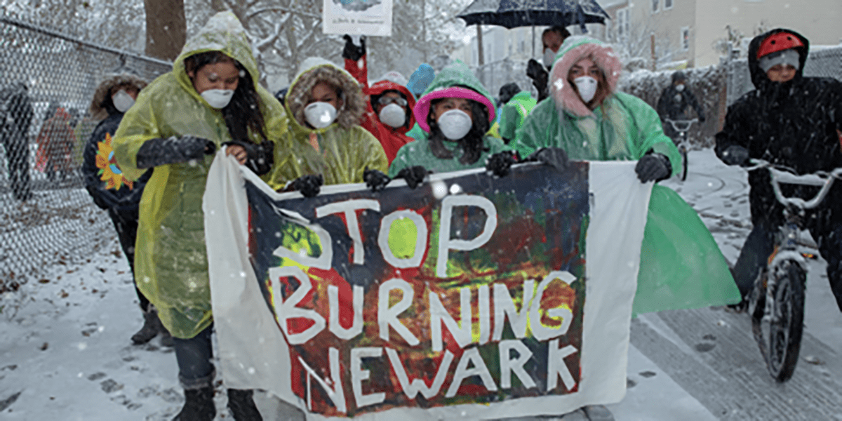 A group of people holding a sign in the snow.